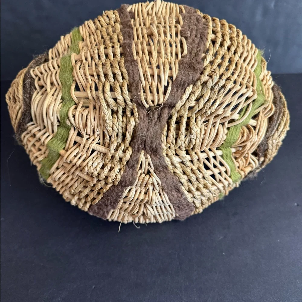 Vintage handwoven basket with brown and green yarn details and eye of God.